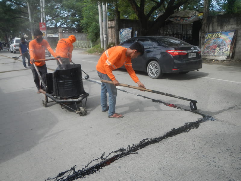 Cuadrilla sellando grietas en el asfalto de una calle