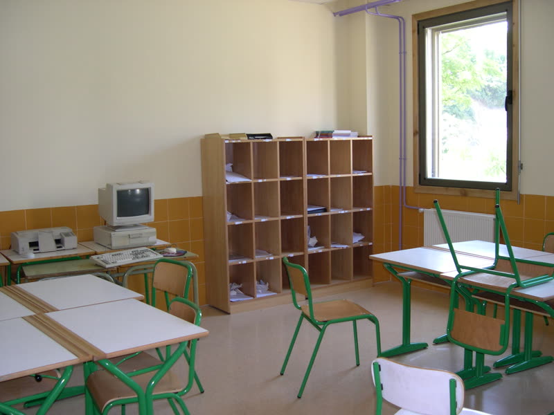 Aula con pupitres, sillas y un armario de casilleros